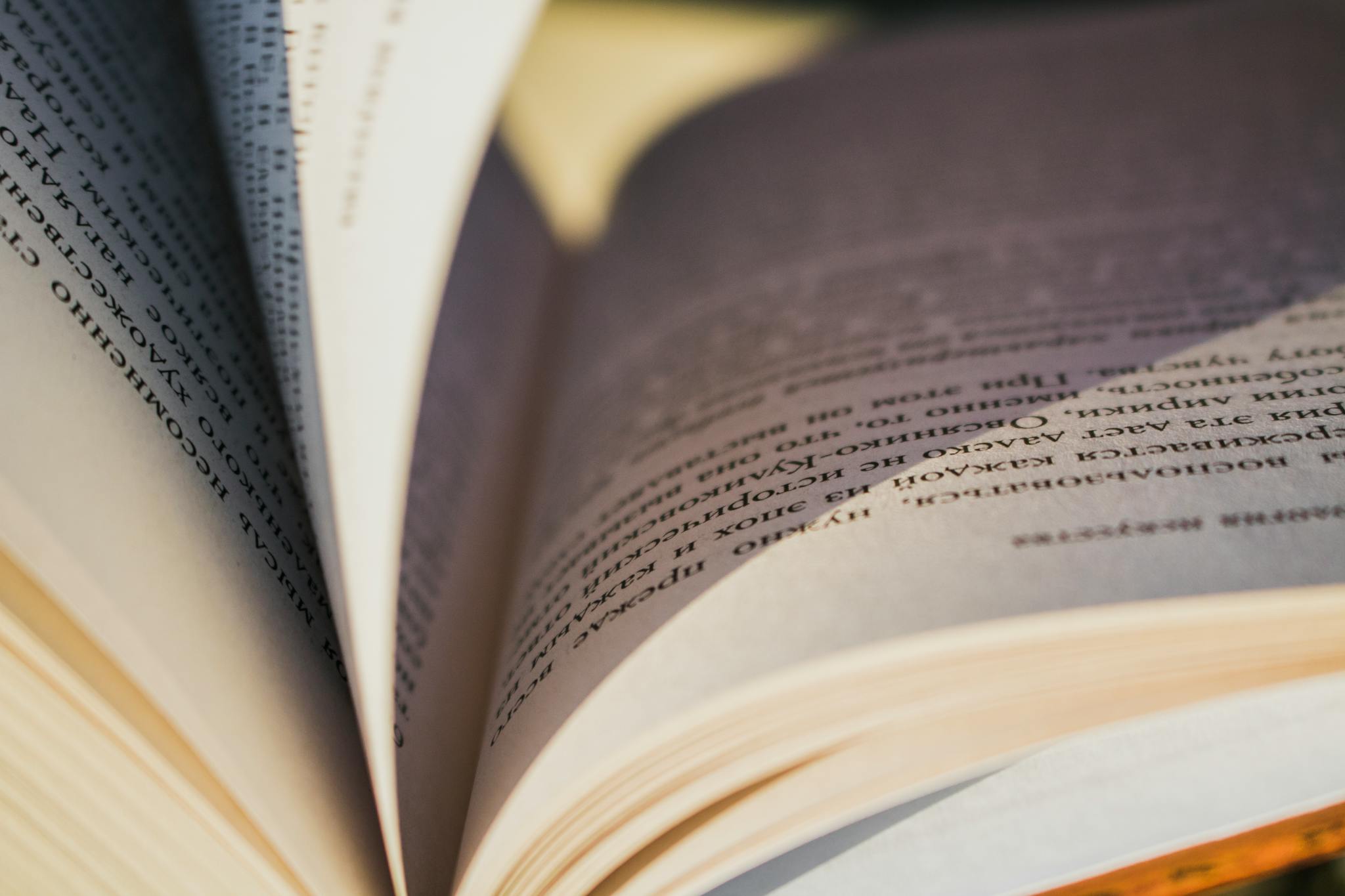 Detailed close-up image of an open book showing the textured pages and printed text.